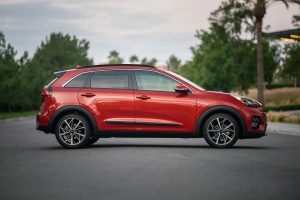 2022 Kia Niro in the color Runaway Red (Orangish red) parked outside.  